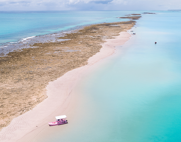 foto aérea de um banco de areias e barreira de corais em meio ao mar