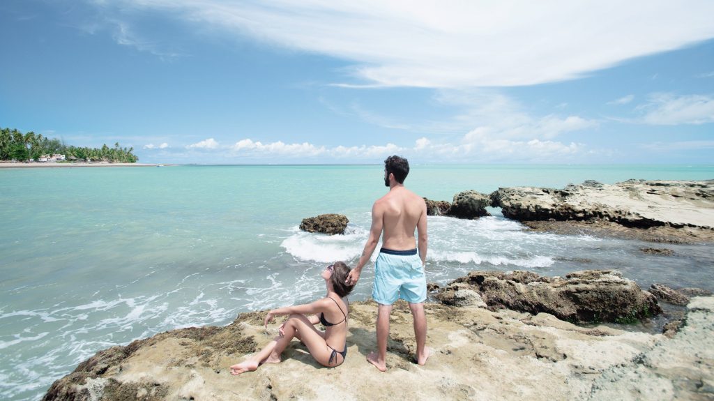 casal em cima das formações rochosas que compõem a praia de barreiras do boqueirão