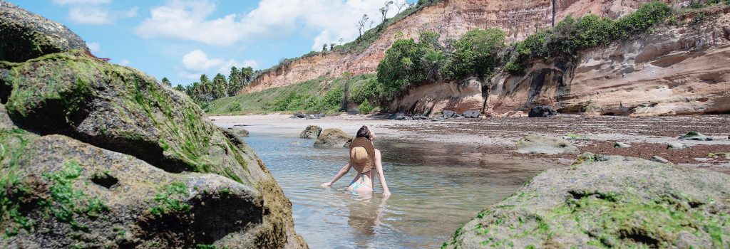 mulher tomando banho nas águas da praia de barreiras do boqueirão