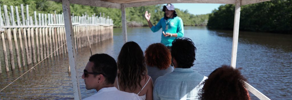 pessoas em uma jangada fazendo o passeio na associação peixe-boi