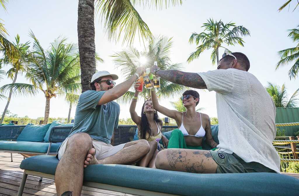 Grupo de amigos brindando e curtindo o clima descontraído na área externa do Japaratinga Lounge Resort, um Resort All Inclusive Premium no litoral de Alagoas.