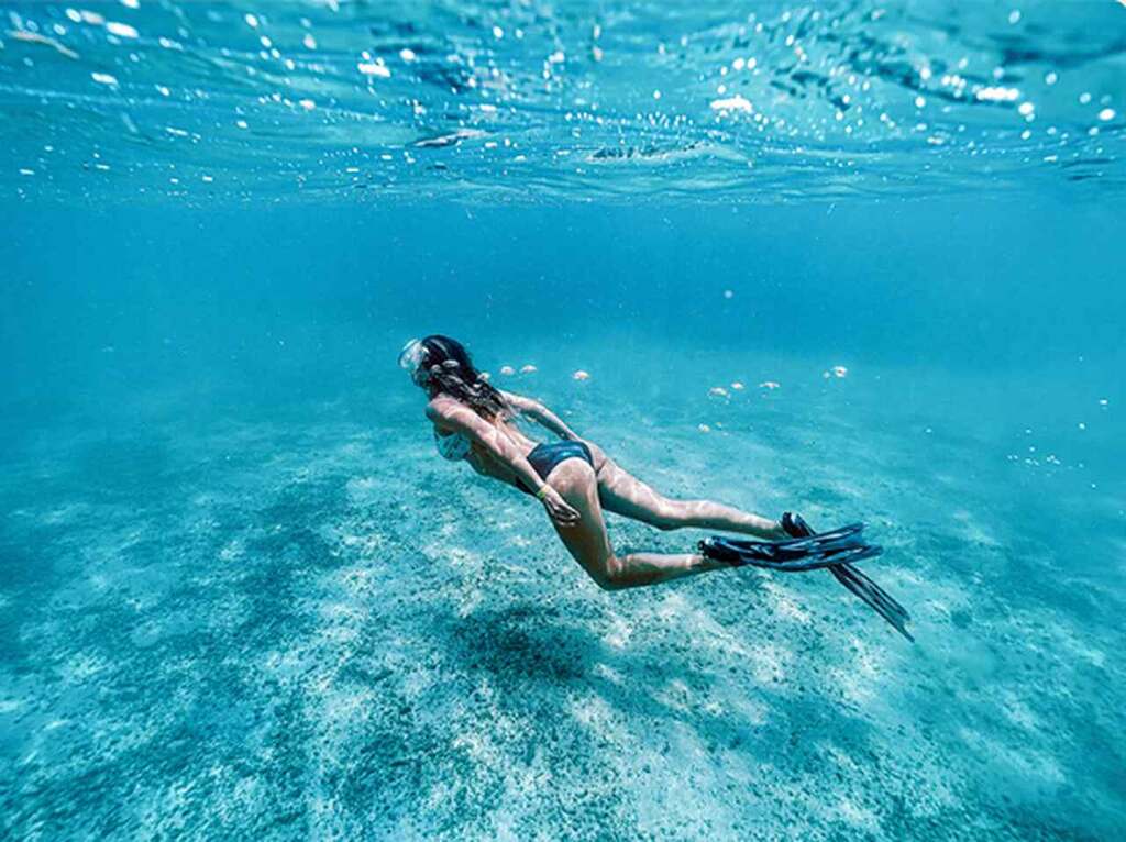 Pessoa praticando mergulho nas piscinas naturais de Japaratinga.
