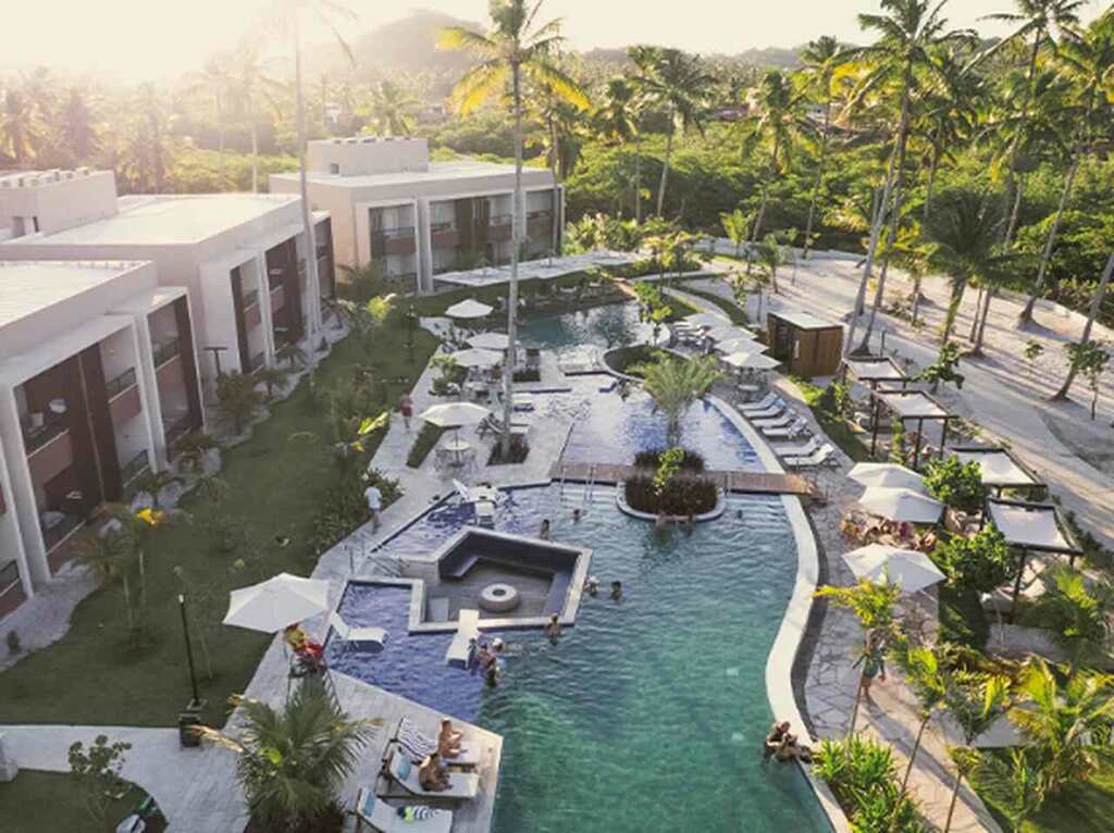 Área de resort próximo às piscinas naturais de Japaratinga, com águas calmas e cenário paradisíaco.