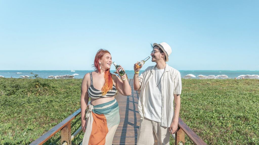 casal bebendo em frente à praia de resort para casal