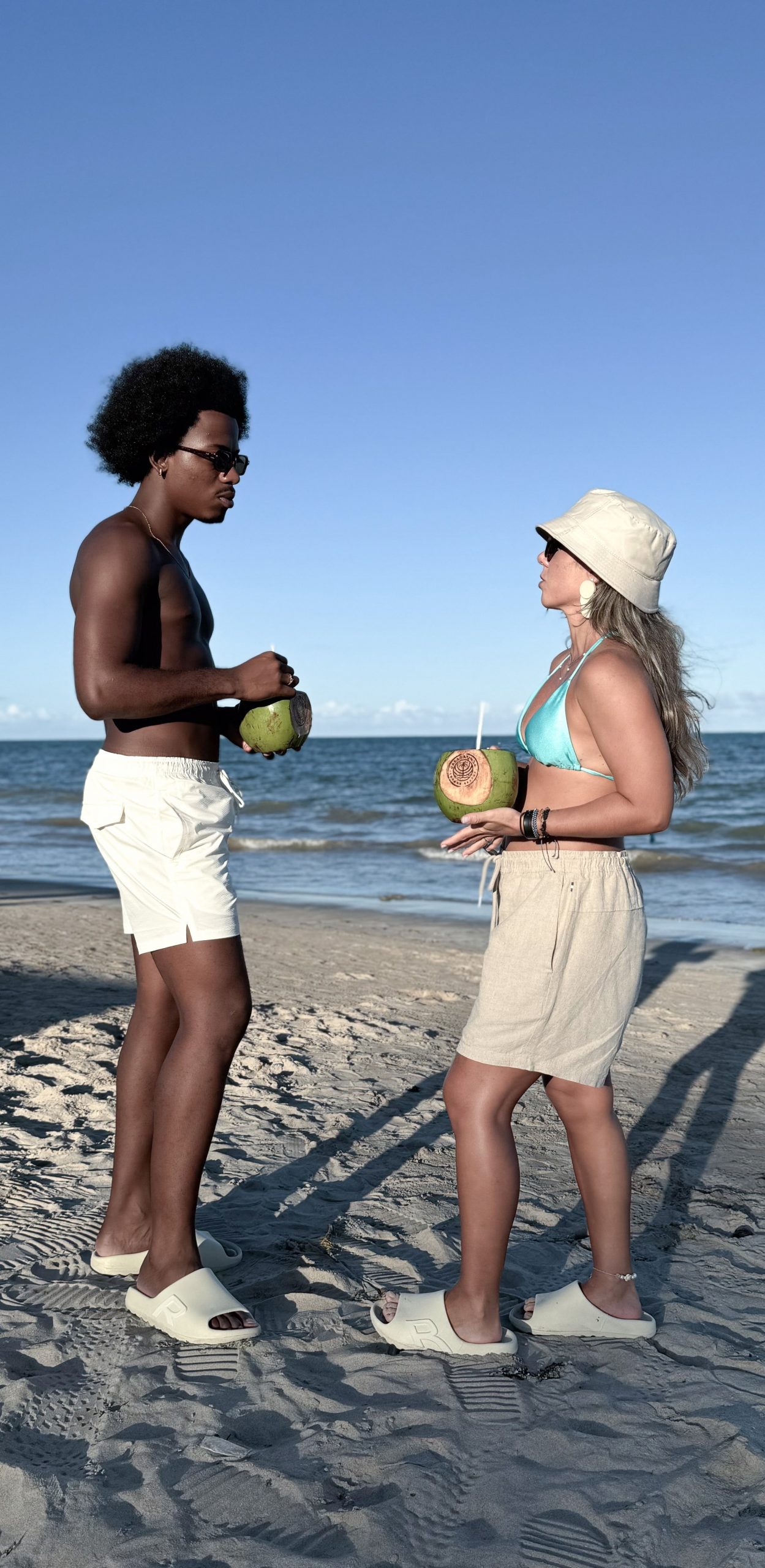 Casal vestindo short da marca Reserva, em parceria com o Japaratinga Lounge Resort.