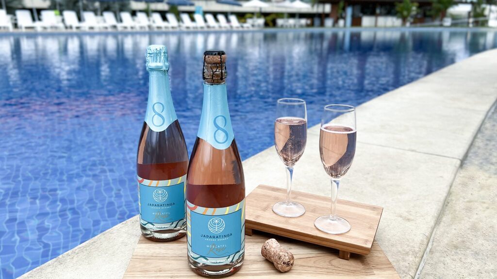 bebidas em frente à piscina de resort, representando a experiência de uma viagem em turismo de luxo