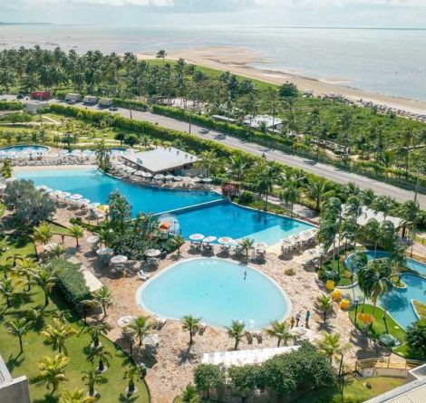 área de lazer com piscina e área verde, representando as vantagens de passar o réveillon em resort
