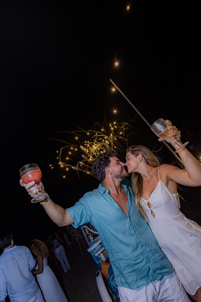 casal aproveitando réveillon em resort com drinks durante a noite