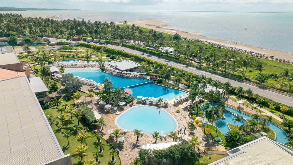 área de lazer com piscina e área verde, representando as vantagens de passar o réveillon em resort