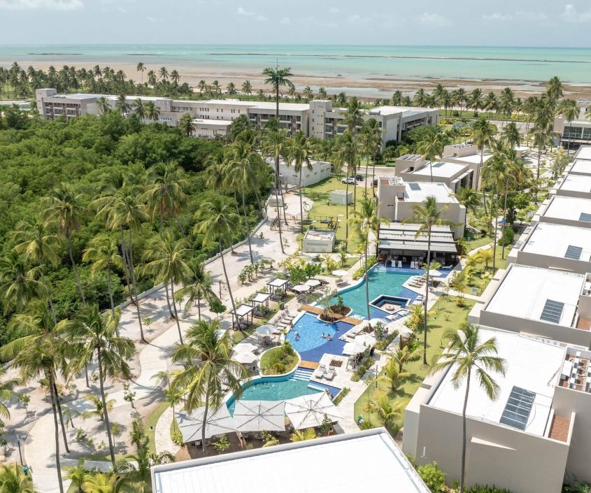 Vista aérea da estrutura da nova categoria Garden Exclusive no Japaratinga Lounge Resort com piscinas, áreas de lazer novos pontos de consumo e vista para a praia ao fundo.