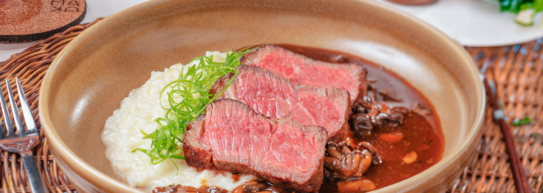 Prato com carne vermelha ao ponto risoto em prato marrom