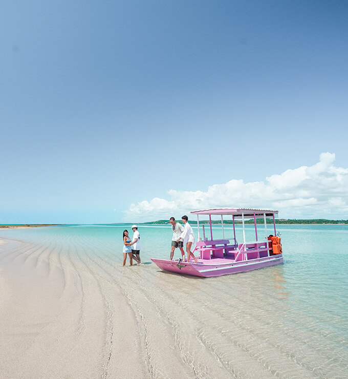 Vista familia com filhos descendo do barco na praia.