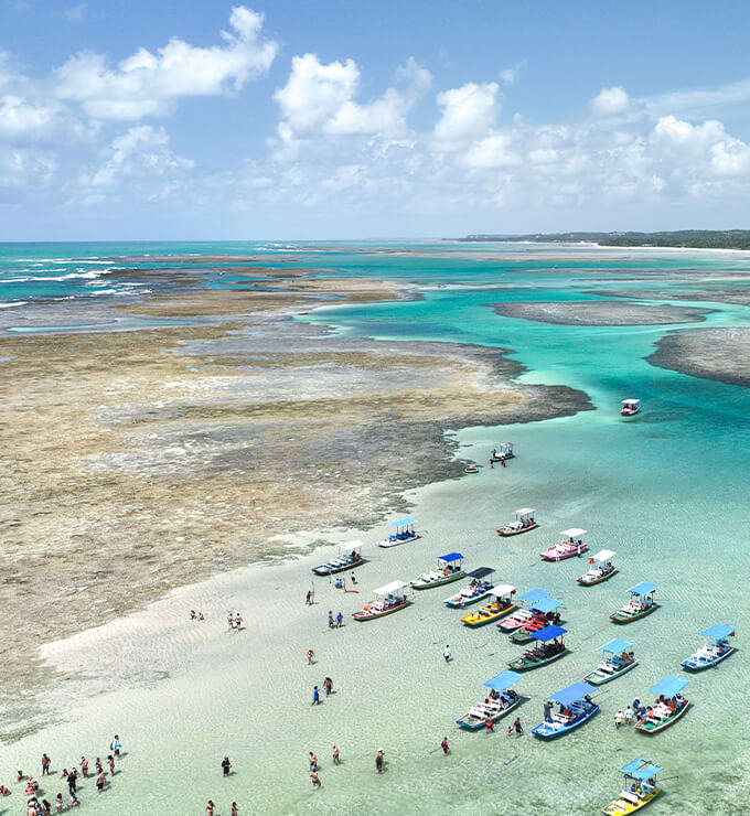 barcos parados e reunidos nos corais com a maré baixa para que as pessoas possam contemplar as belezas naturais.
