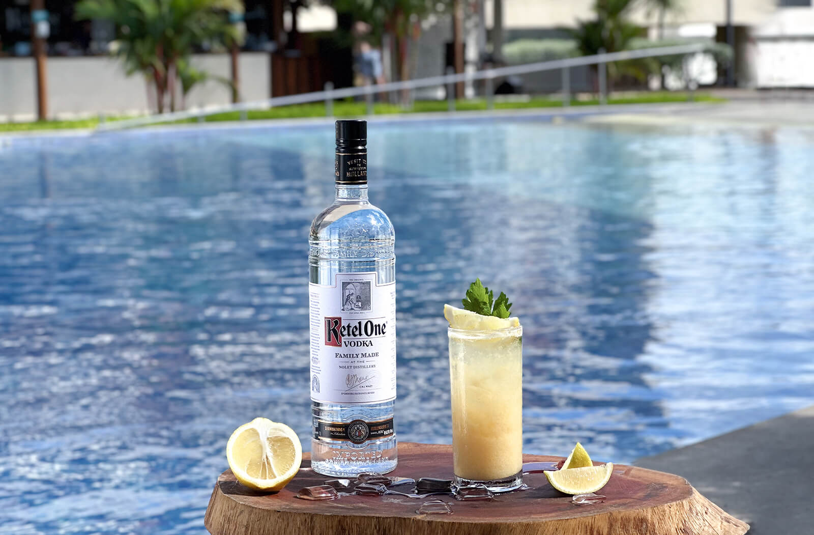 imagem de uma garrafa de vodka da marca ketel one, um limão partido e um copo com drink feito de vodka.