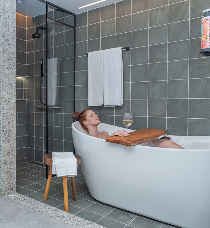 Imagem mostrando mulher feliz na banheira do apartamento Garden Exclusive.