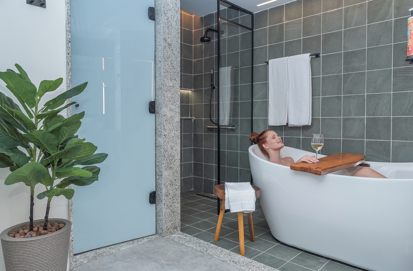 Imagem mostrando mulher feliz na banheira do apartamento Garden Exclusive.