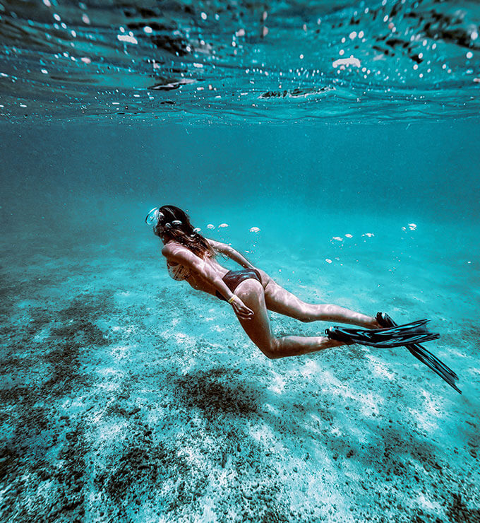 Mulher fazendo mergulho com nadadeiras