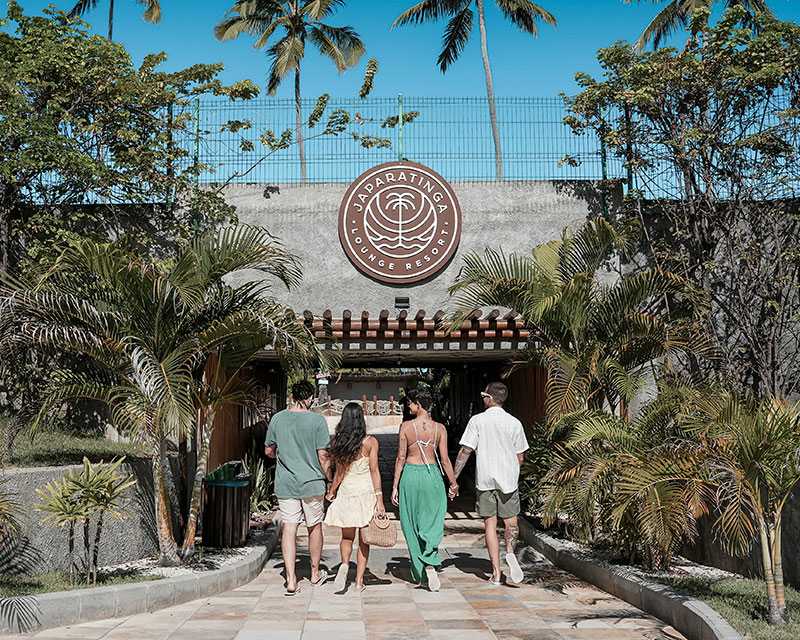 Imagem mostra quatro amigos passando pelo túnel do Japaratinga Lounge Resort.