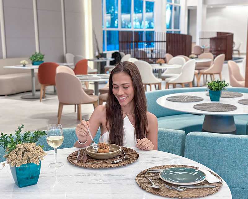 Imagem mostra mulher degustando pratos especiais no Restaurante Maka.