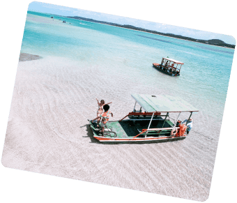 Barcos de passeio ancorados no raso da praia cristalina de Japaratinga.