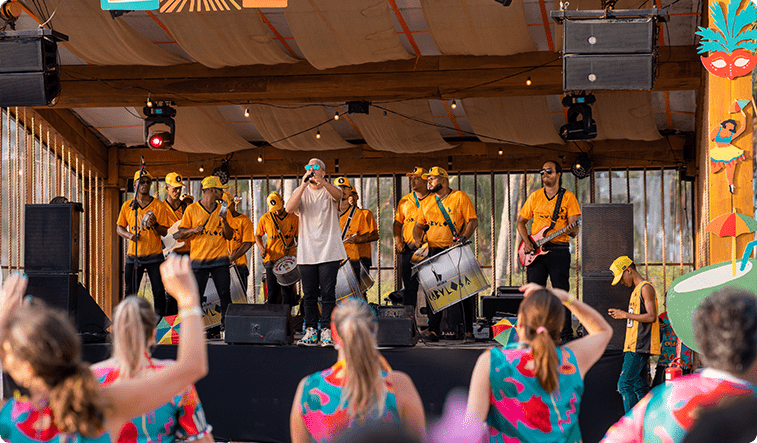Show de carnaval na praia com pessoas de abadá dançando