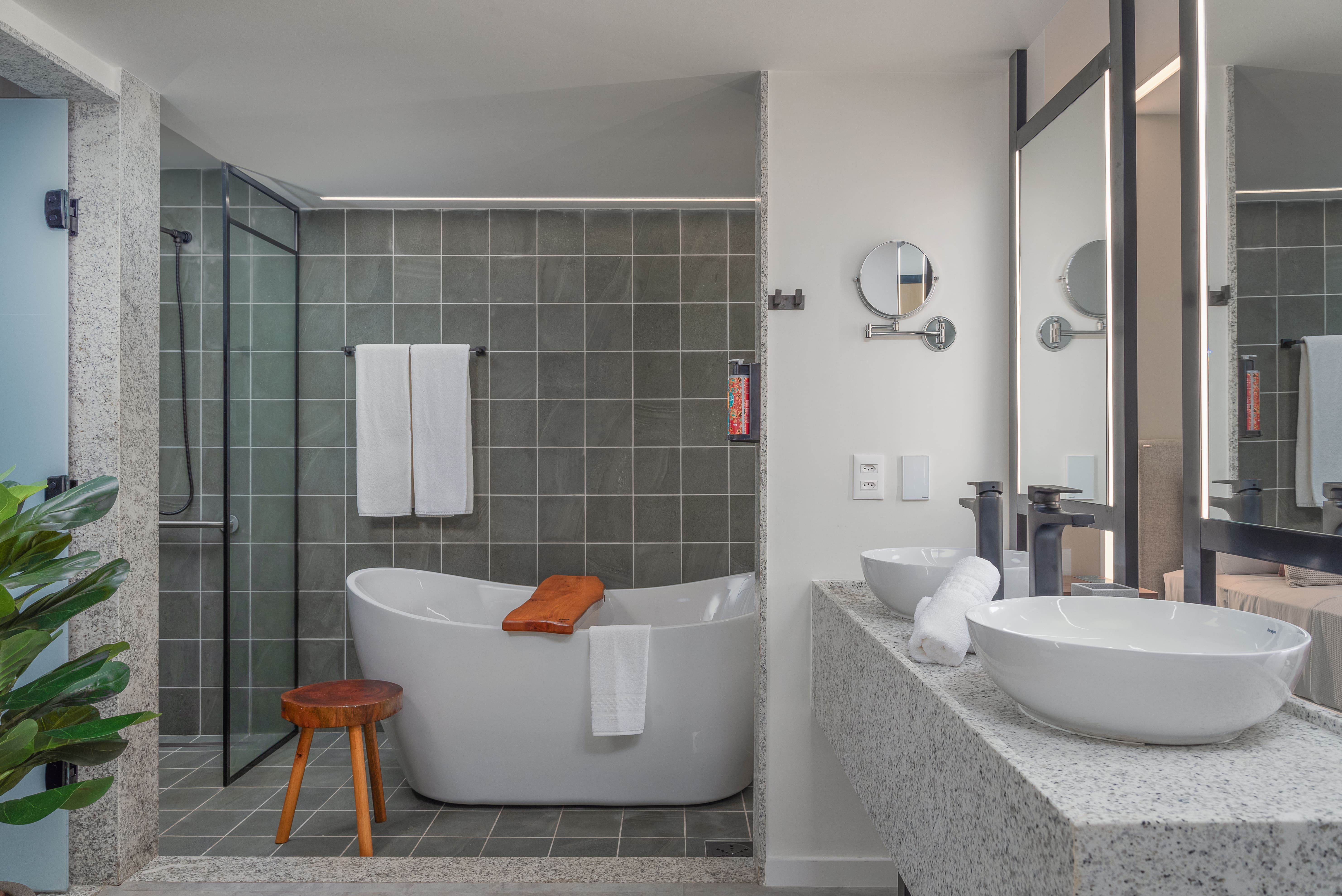 Imagem da área de banho do Garden Exclusive, com duas pias, banheira de imersão, ducha e mais.