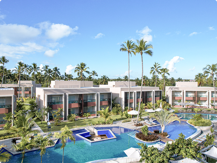 Vista aérea do Japaratinga Lounge Resort ao entardecer, mostrando
a área das piscinas cercadas por vegetação tropical e palmeiras