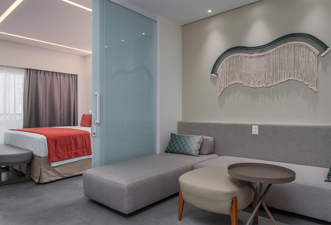 O conforto da Garden Suíte, com dois ambientes, um da cama e outro com um grande sofá.